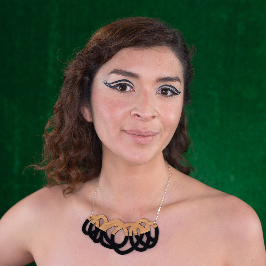 Chunky black and wood statement necklace shown on model