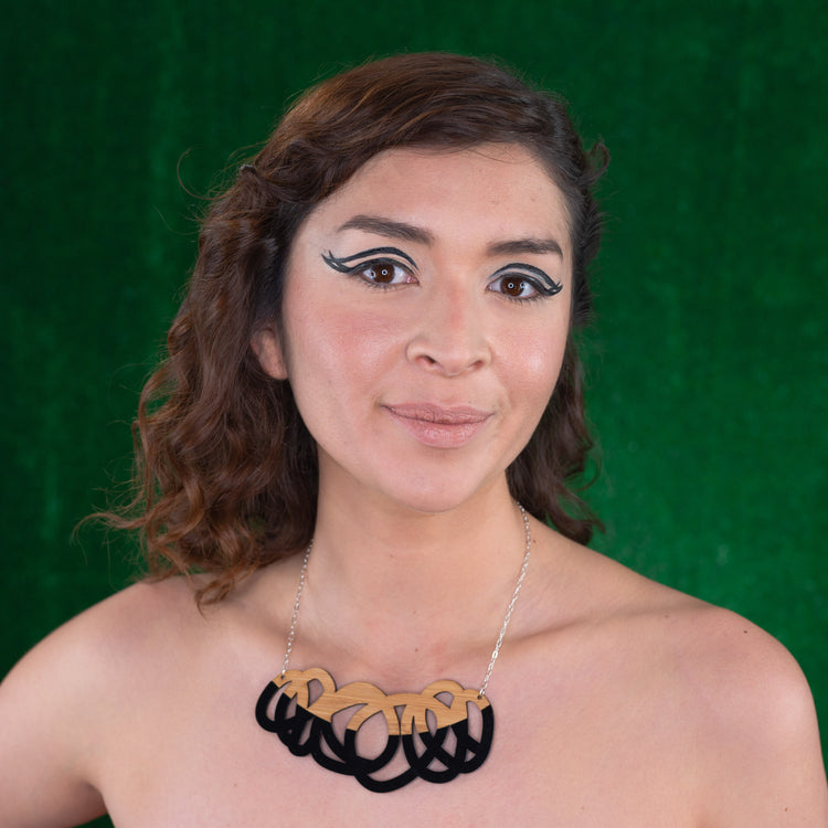 Chunky black and wood statement necklace shown on model