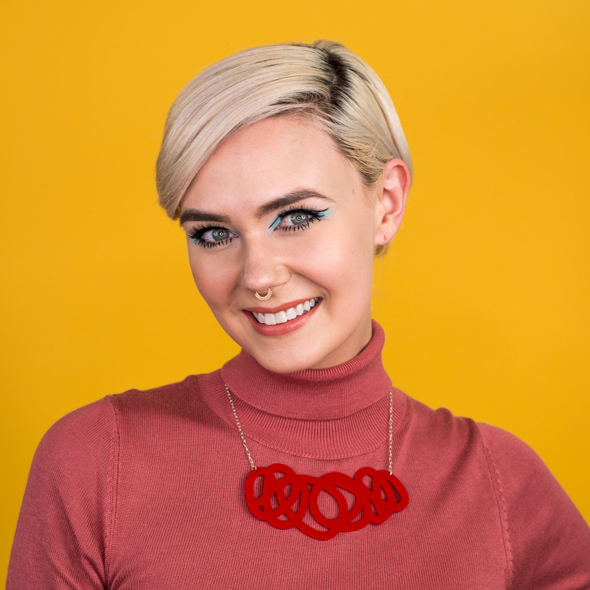 Chunky red statement necklace shown on model