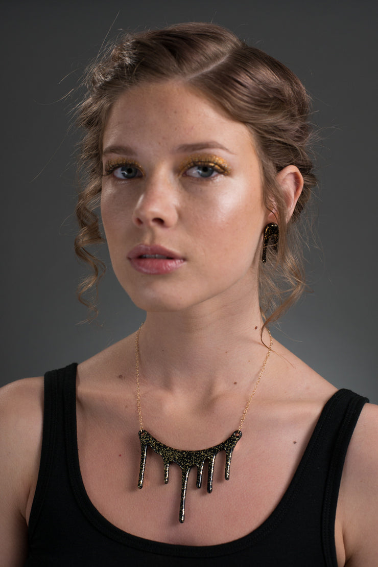 black and gold glitter necklace on model