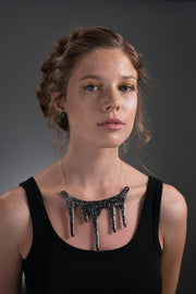 black and silver drop earrings on model