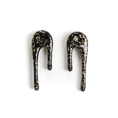 black and gold drop earrings over white