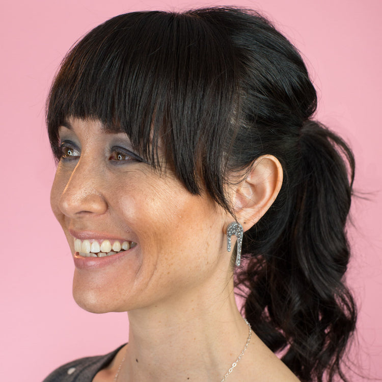 sparkly silver stud earrings on model