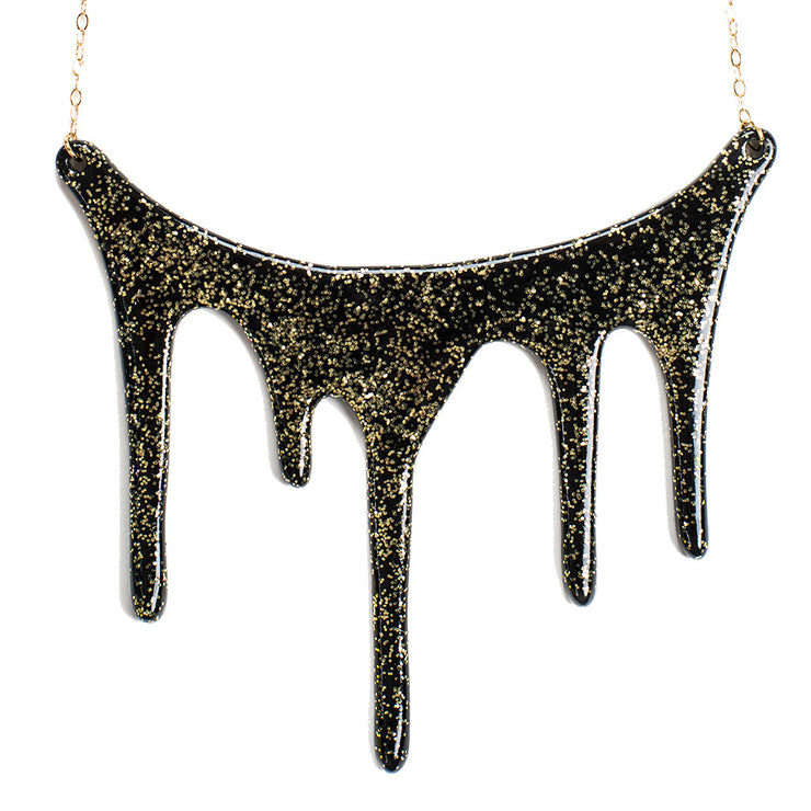 drip black and gold glitter necklace over white