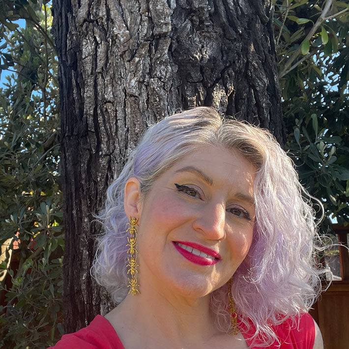 gold ant earrings on model