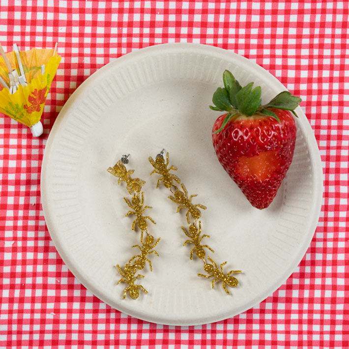 gold ant earrings pictured at a picnic