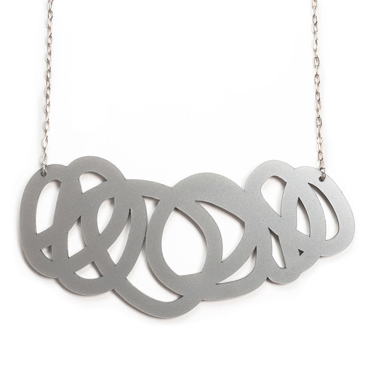 Chunky silver statement necklace on on white background