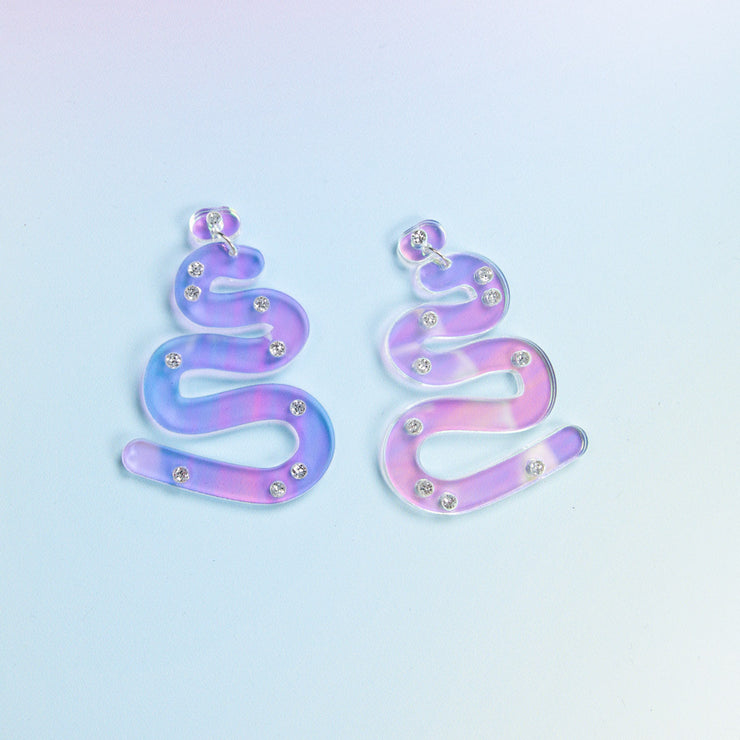 iridescent squiggle earrings on blue background