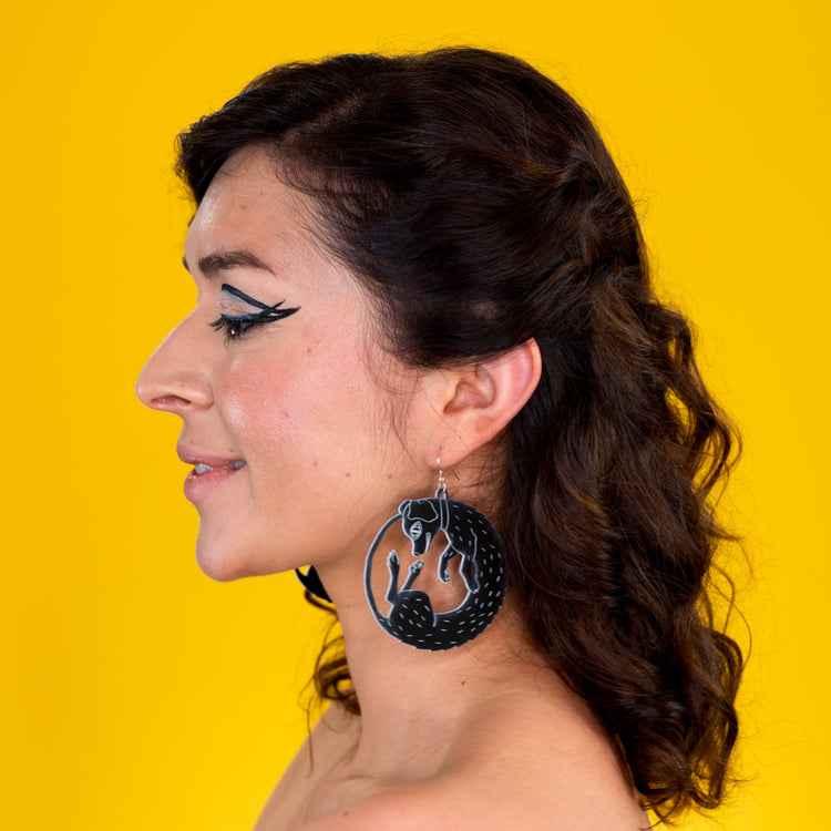 Large black dog earrings on model