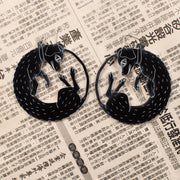 large black dog earrings on newspaper