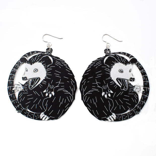 large black and white possum earrings over white