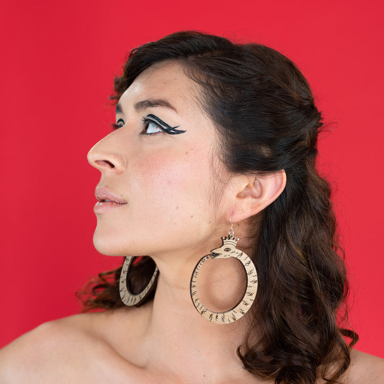 large wood ouroboros earrings on model