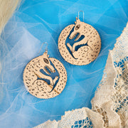 large wood wolf earrings on blue background