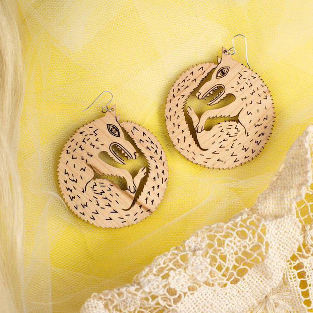 large wood wolf earrings on yellow background