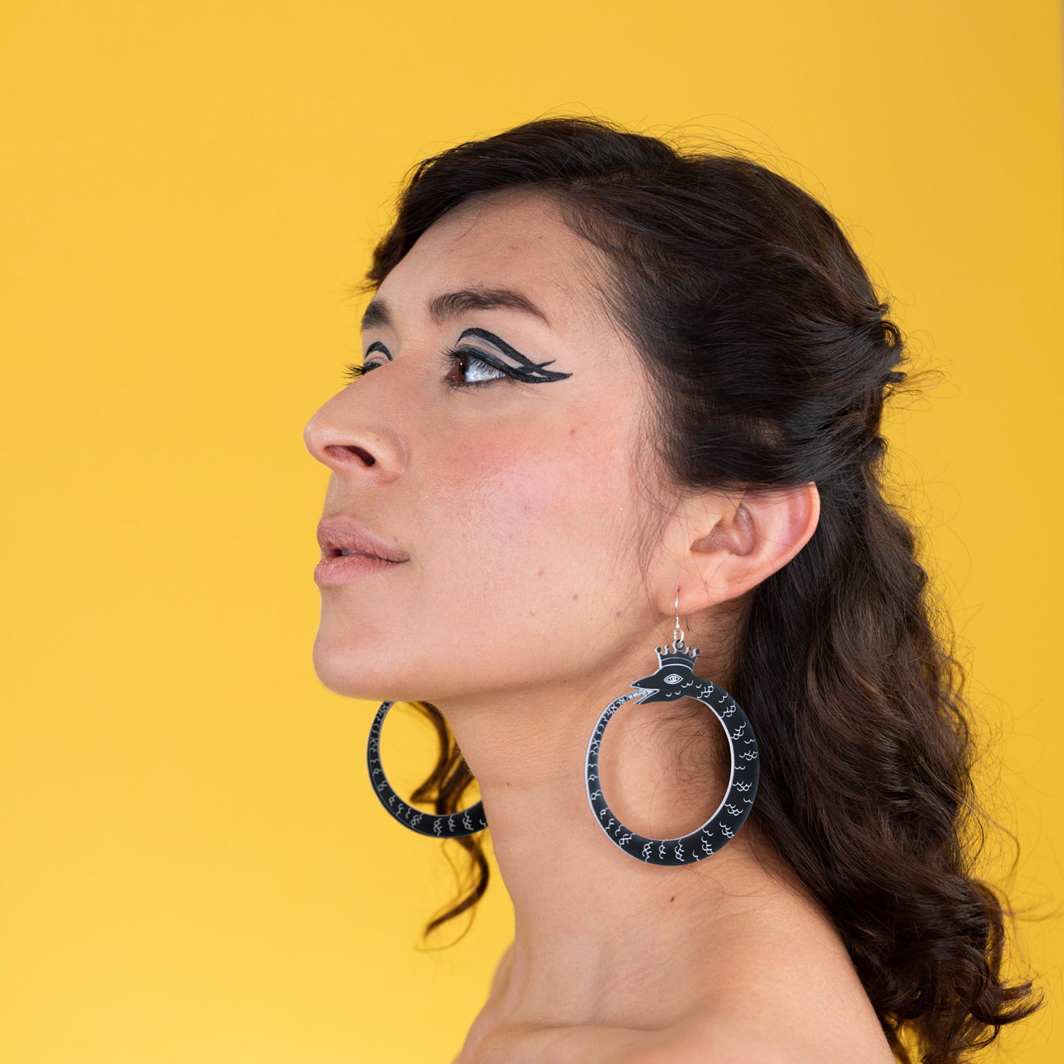 large black ouroboros earrings on model