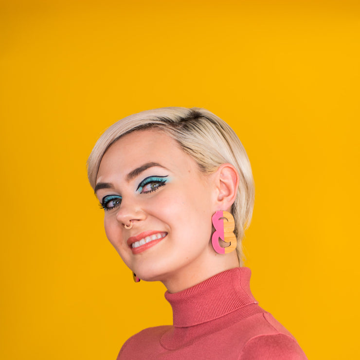 Pink and wood statement stud earrings on model