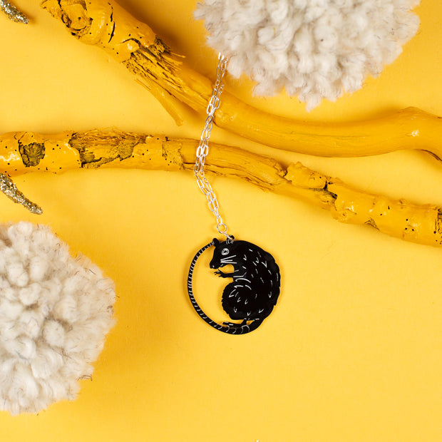 rat necklace on yellow background