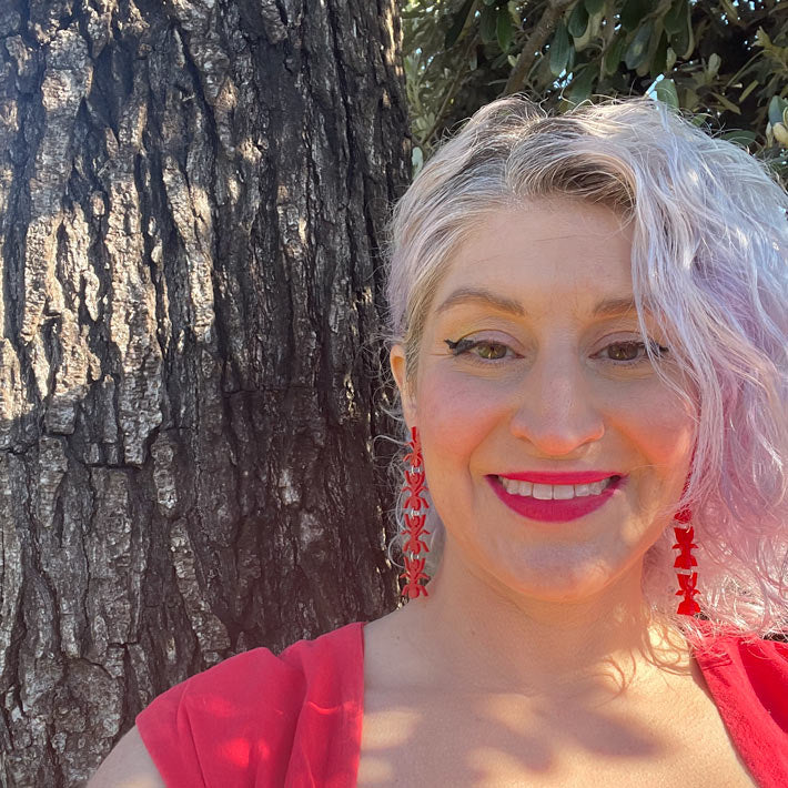 red ant earrings on model