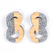 silver and wood statement studs on white background
