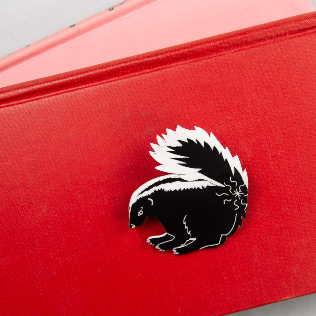 Skunk pin on red background