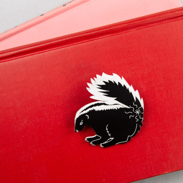 Skunk pin on red background