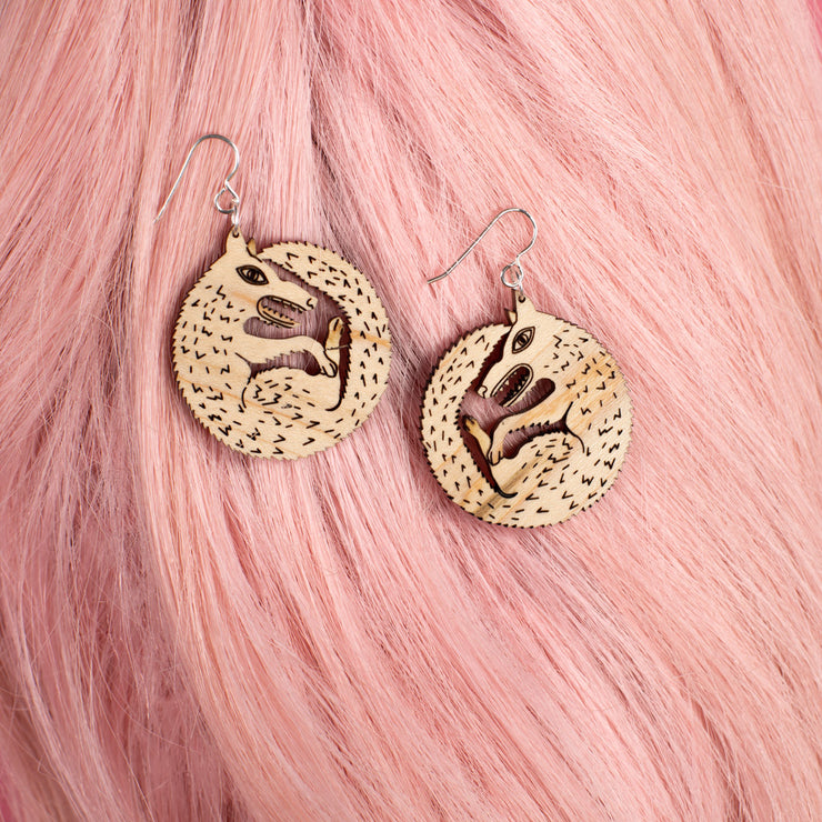 small wood wolf earrings on pink