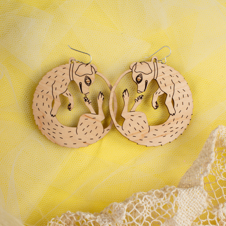 small wood dog earrings on yellow background