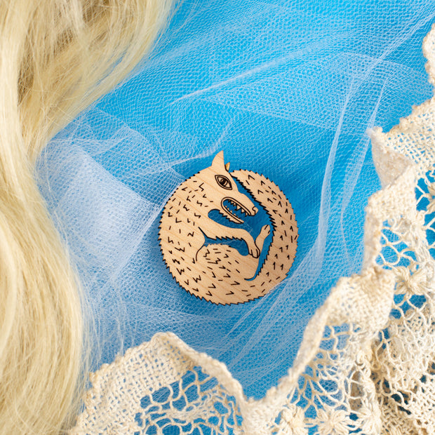 wood wolf pin on blue background