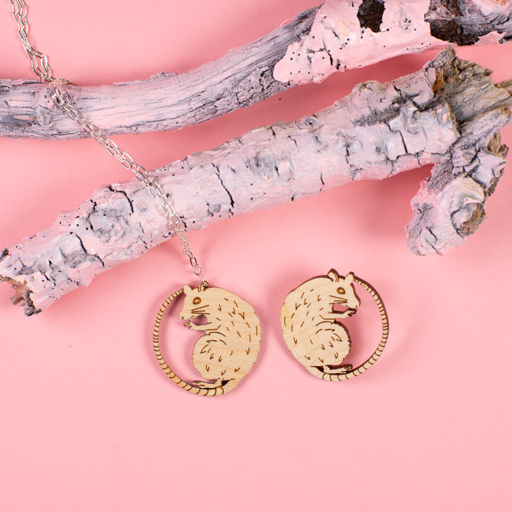 wood rat necklace and wood rat pin on pink background