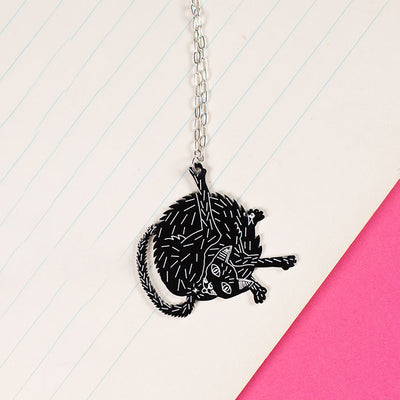 black cat necklace styled on notebook paper