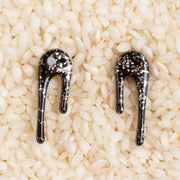 black and silver drop earrings in bowl of rice