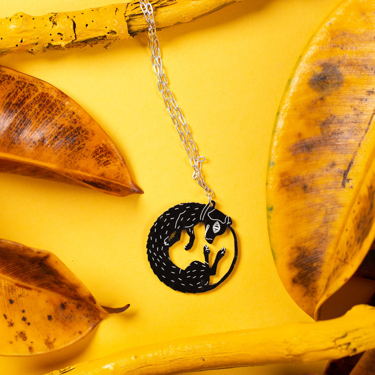 black dog necklace on yellow background