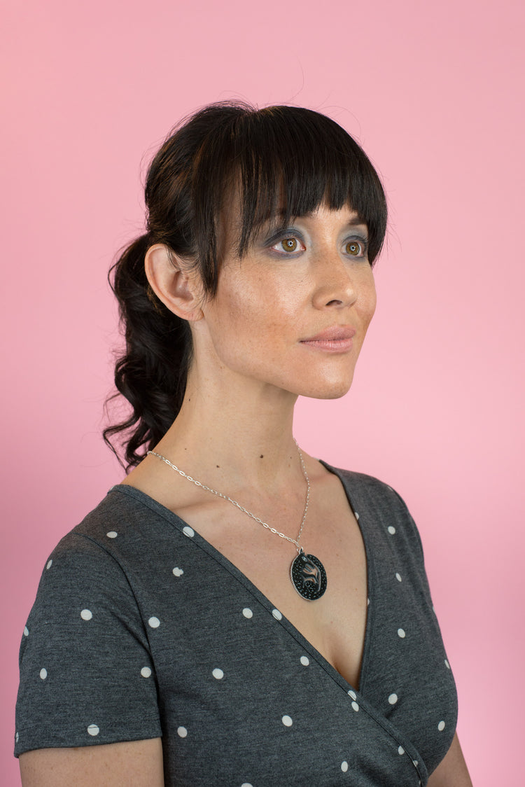 black wolf necklace on model