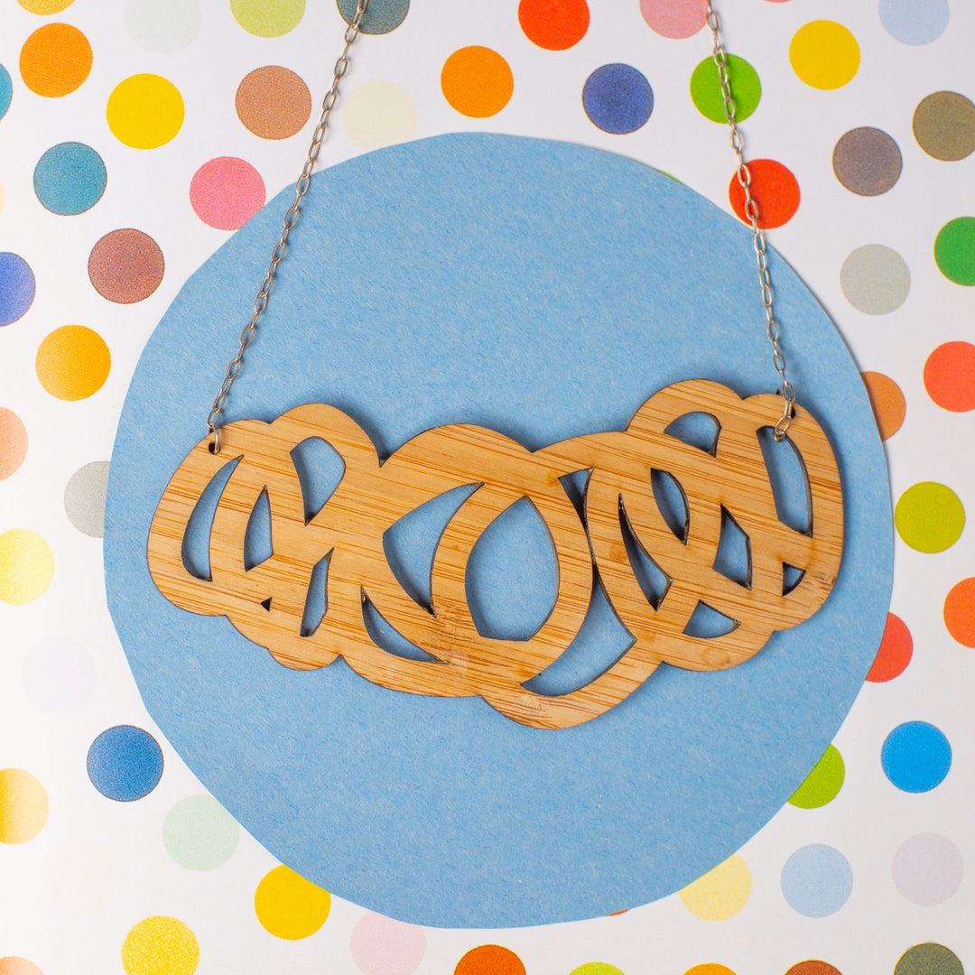 Chunky wood statement necklace shown on polka dot paper