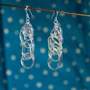 iridescent dangle earrings over blue background