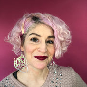 Iridescent statement earrings shown on model with short pink hair