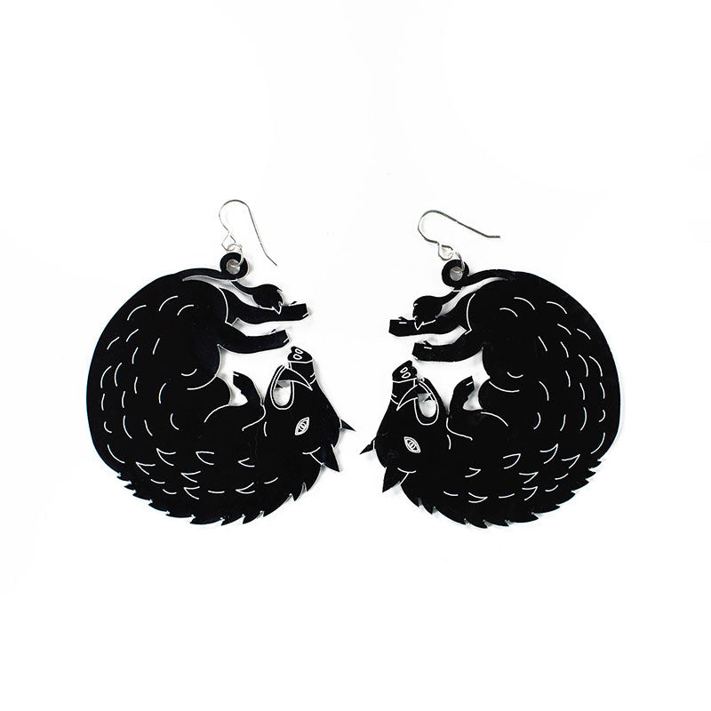 large black boar earrings over white background