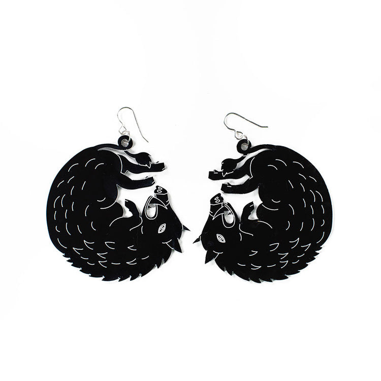 large black boar earrings over white background