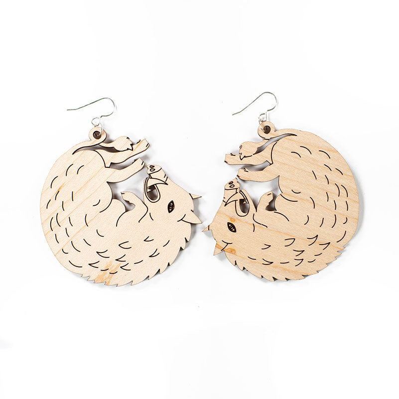 large wood boar earrings over white background