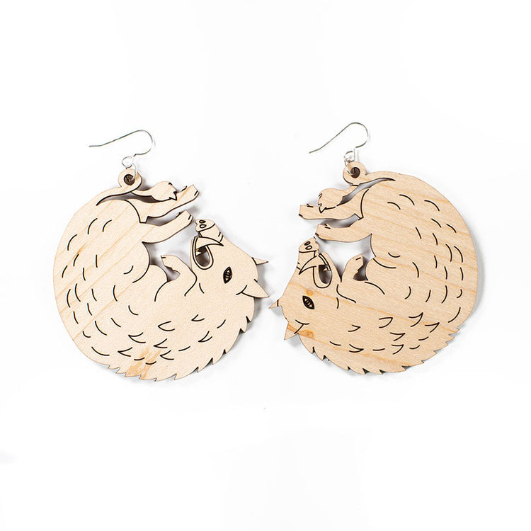 large wood boar earrings over white background