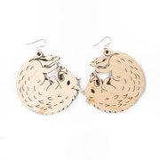 large wood boar earrings over white background