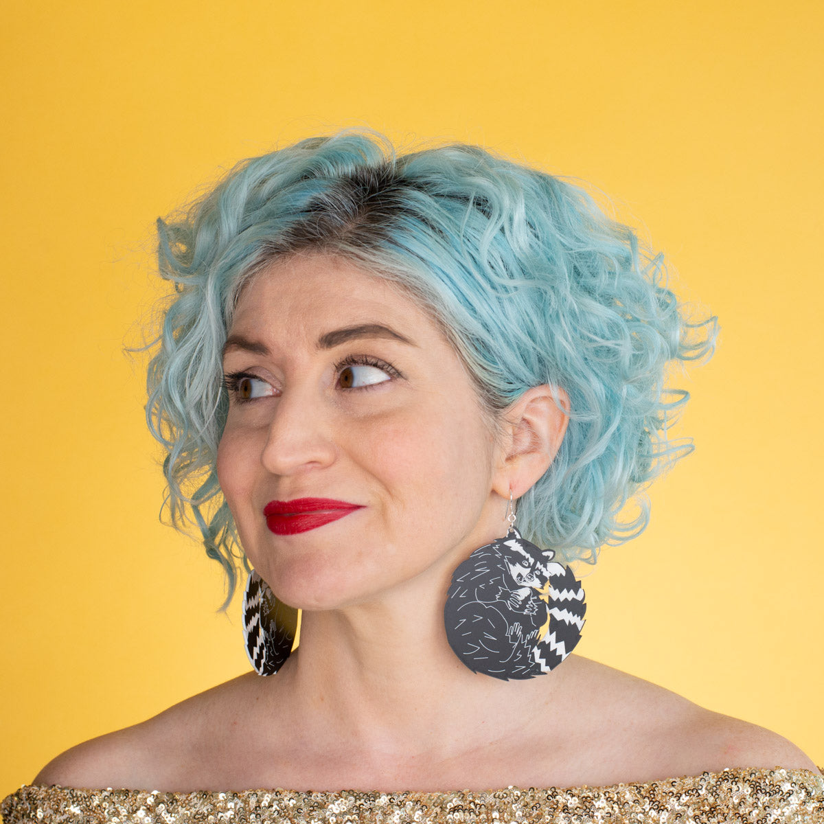 Big raccoon earrings on model with blue hair