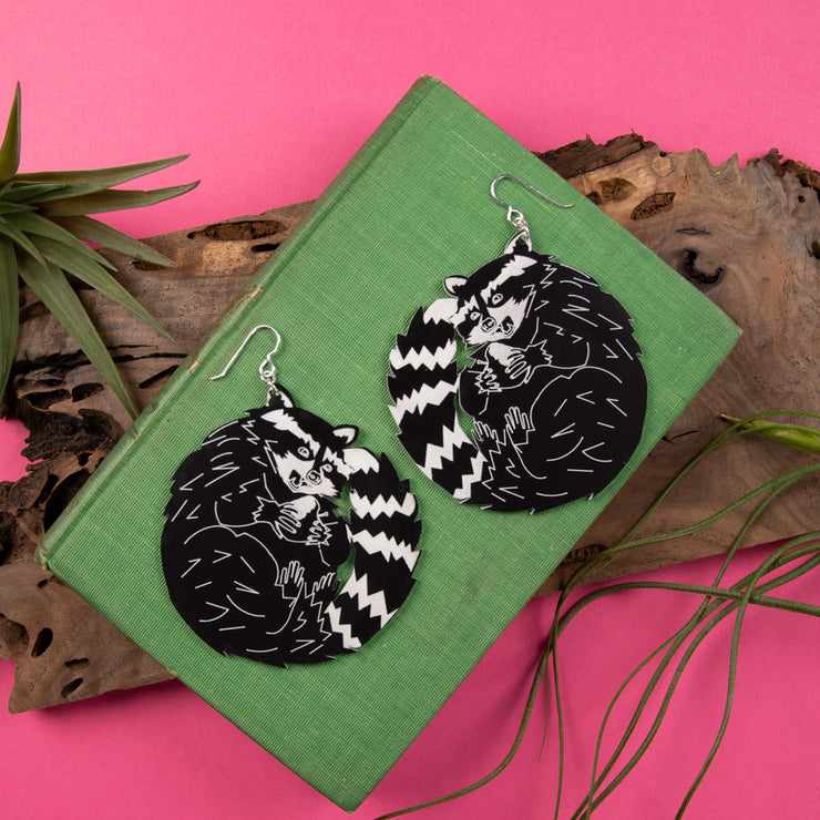 big raccoon earrings on green book