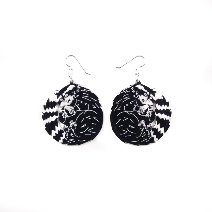 black and white raccoon earrings on white background