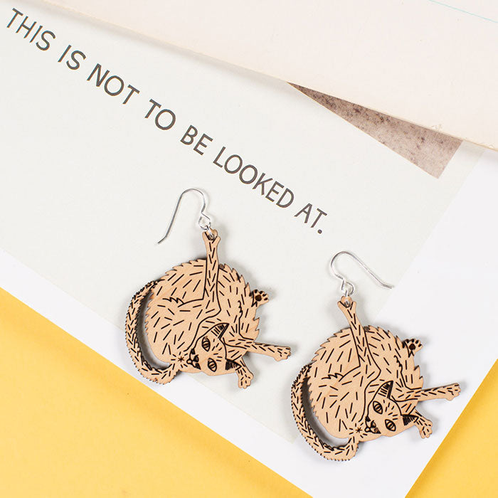 small wood cat earrings styled on magazine
