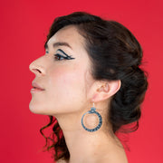 small black ouroboros earrings on model