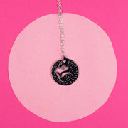 black wolf necklace on pink background
