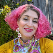 Large white sunglass earrings shown on model with pink hair