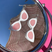 Large white sunglass earrings shown on mirror