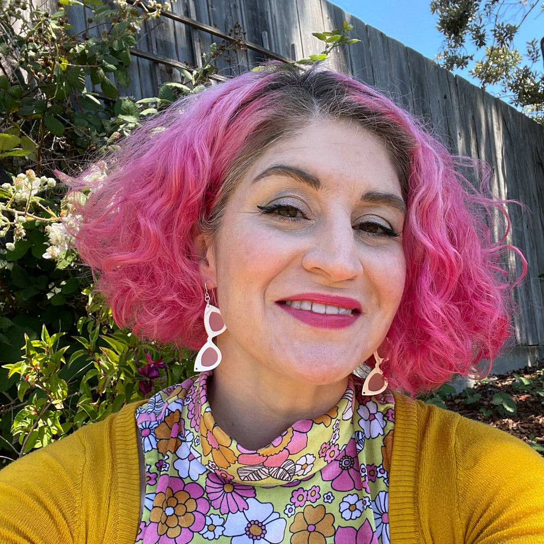 Small White sunglass earrings on model with pink hair